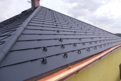 Položeno, detail na nároží, falcovaný šindel, protisněhové háky, měděný žlab včetně uchycení Položeno, detail na nároží, falcovaný šindel, protisněhové háky, měděný žlab včetně uchycení